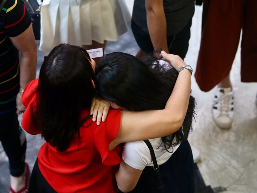 A student being consoled at Nanyang JC. Students affected by the theft of the GCE A-Level H2 Chemistry paper 3 examination scripts were given a slip of paper informing them of a briefing. Photo: Koh Mui Fong/TODAY