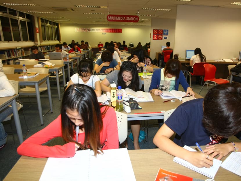 Students studying at the MDIS library. Based on anecdotal evidence, a growing group of young Singaporeans are opting to study at private institutions here instead of public universities, so they can get their degree faster. Today File Photo