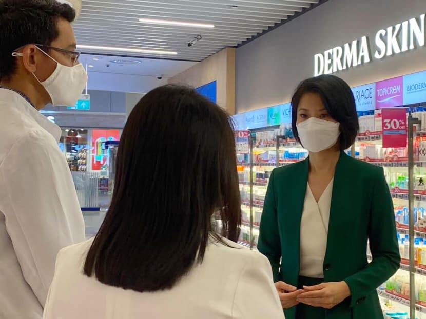 Ms Sun Xueling (right), Minister of State for Social and Family Development, speaking to Unity Pharmacy staff members who are trained to detect family violence.