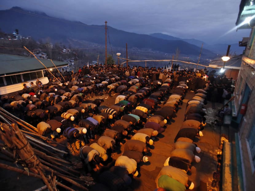 Kashmiri Muslim devotees offer prayers before participating in a torch light procession on a hilltop near the shrine of Muslim saint Sakhi Zain-ud-din Wali, in Aishmuqaam, about 80km south of Srinagar, India, on Friday, April 3, 2015. Photo: AP