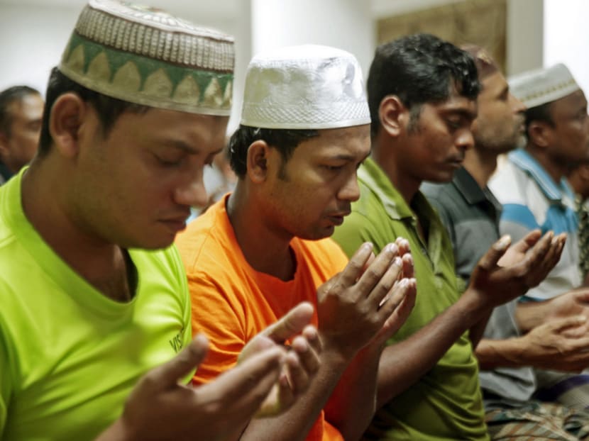 Migrant workers during a prayer session at the dormitory in 

Kaki Bukit, where the Community Engagement and Religious Guidance programme will be launched tomorrow. 

Photo: Jason Quah