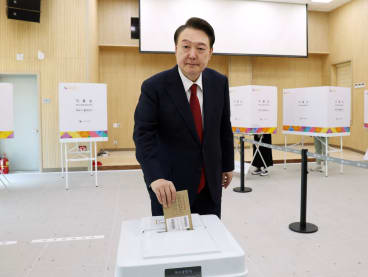 South Korea's President Yoon Suk Yeol casts his ballot during early voting at a polling station in Busan on April 5, 2024.
