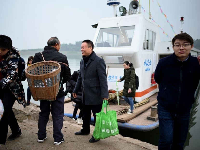 This photo taken on Nov 29, 2020, shows passengers getting off Mr Yang Zeqiang's boat as it arrives at the bank opposite Zhongba, a small island near to the southwestern city of Chongqing. This photo taken on Nov 29, 2020, shows passengers getting off Mr Yang Zeqiang's boat as it arrives at the bank opposite Zhongba, a small island near to the southwestern city of Chongqing.