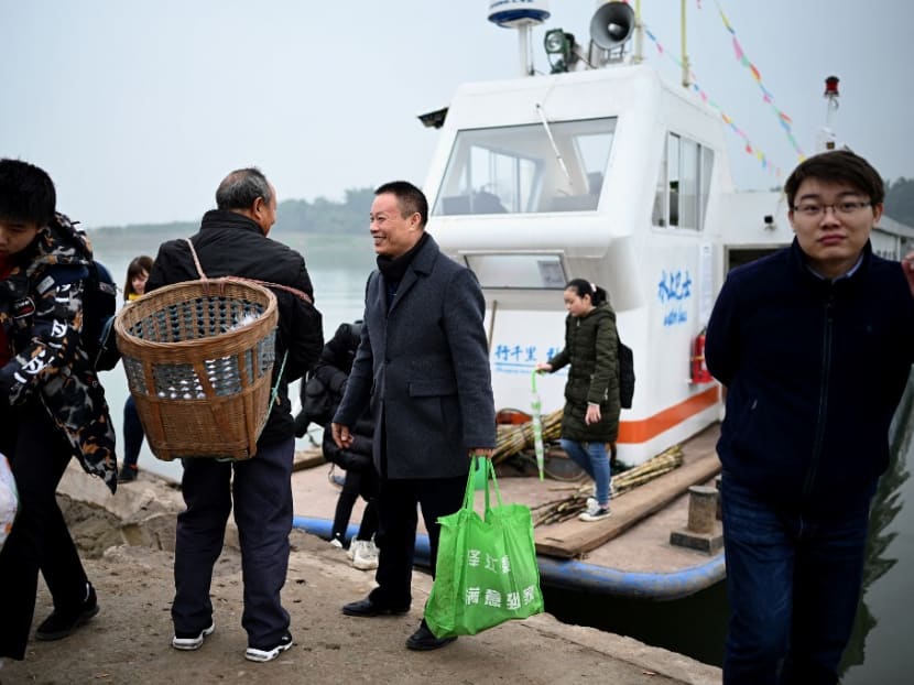 This photo taken on Nov 29, 2020, shows passengers getting off Mr Yang Zeqiang's boat as it arrives at the bank opposite Zhongba, a small island near to the southwestern city of Chongqing.