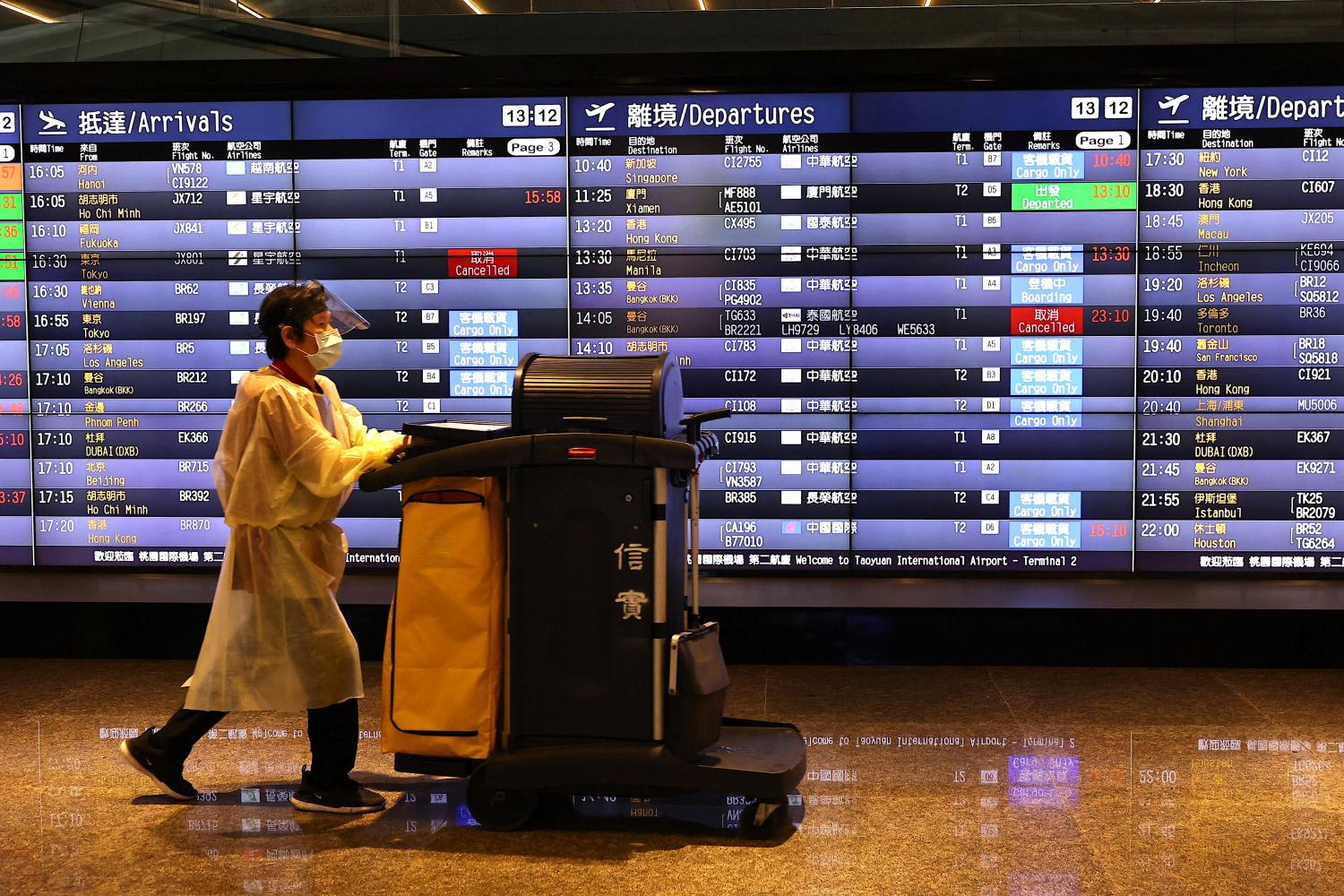 A airport staff walks past a board showing departure statuses at Taoyuan International Airport in Taiwan, on Aug 4, 2022. A airport staff walks past a board showing departure statuses at Taoyuan International Airport in Taiwan, on Aug 4, 2022.