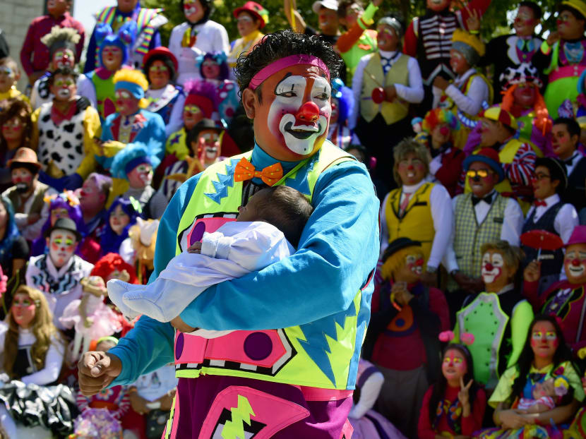 A clown holds a baby at the XXI Convention of Clowns, at the Jimenez Rueda Theatre, in Mexico City. Photo: AFP
