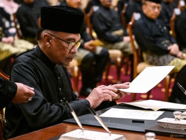 Malaysia's newly appointed Prime Minister Anwar Ibrahim signs documents after taking the oath during the swearing-in ceremony at the National Palace in Kuala Lumpur, Malaysia on November 24, 2022. Mohd Rasfan/Pool via REUTERS