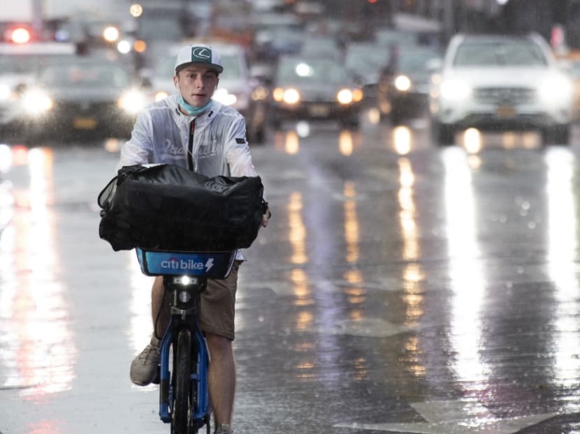 A man rides a bicycle as rain falls in Times Square as Tropical Storm Henri approaches, in New York on Aug 22, 2021.