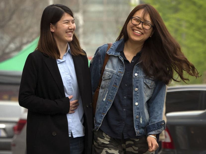 Chinese activist Li Tingting (left) and her girlfriend, who wished to be identified only as Teresa laugh as they walk along a street in suburban Beijing. Photo: AP