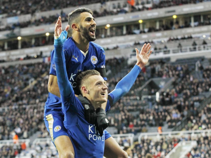 Jamie Vardy (standing) celebrates with Riyad Mahrez after scoring the first goal for Leicester City to equal the record for scoring in consecutive Premier League games. Photo: Reuters