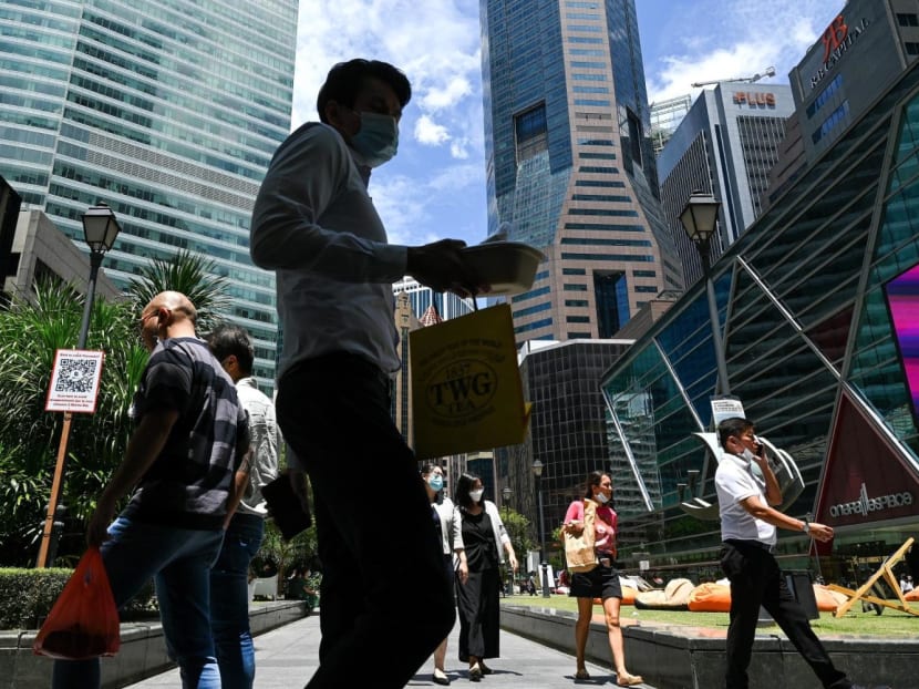 Office workers walking around the Raffles Place financial business district in August 2022.
