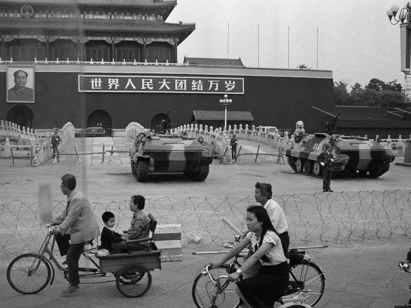 Cyclists passing armoured vehicles parked in front of Tiananmen Gate on June 13, 1989. China makes repeated references to history and it is noticeable when they are suddenly absent. Photo: AP