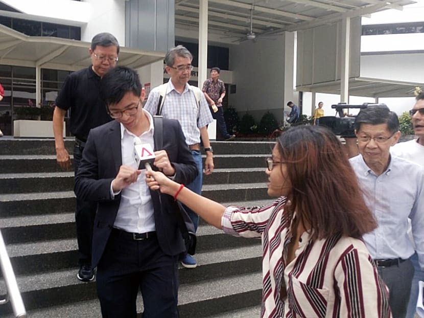 HDB officer Ng Han Yuan (in black suit), 25, was fined S$2,000 for breaching the Official Secrets Act by "wrongfully communicating confidential information" to a Straits Times reporter. Photo: Faris Mokhtar/TODAY
