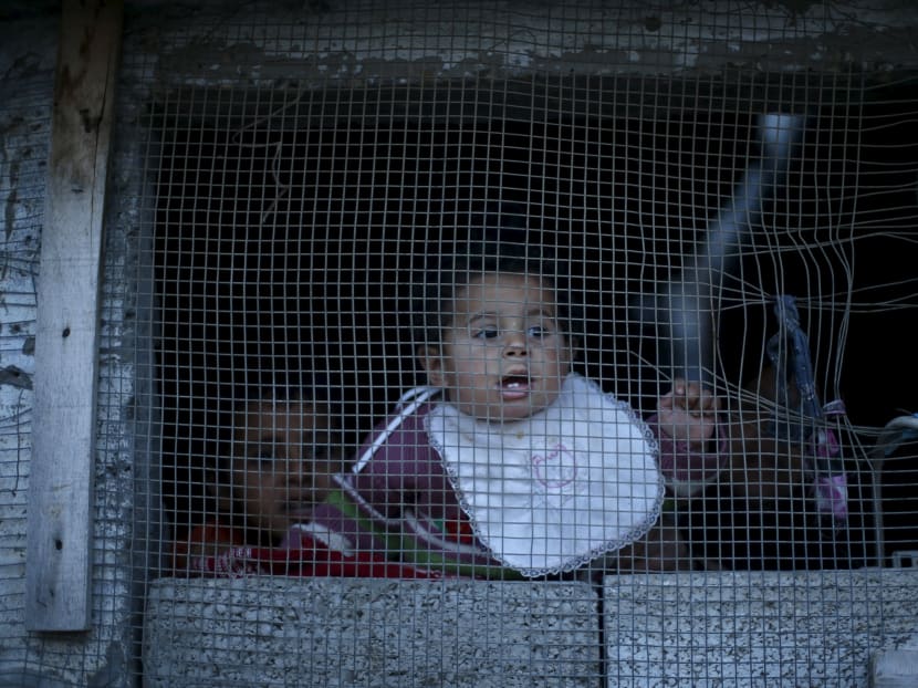 A Palestinian girl looks out through the window of her family's house in the northern Gaza Strip. Photo: Reuters