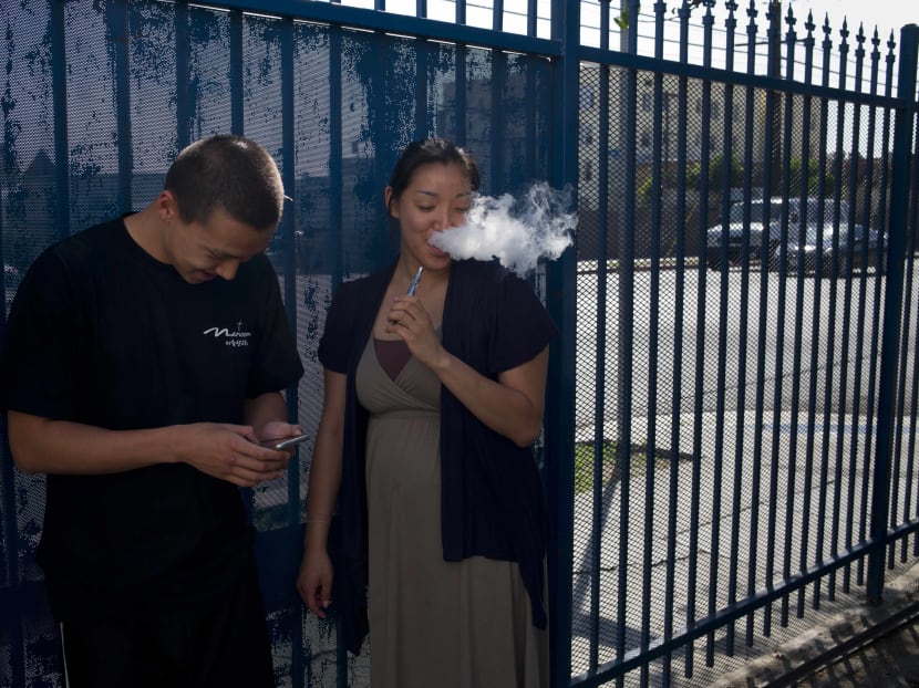 In this July 29, 2015 photo, drug rehab residents, Kevin Lim, left, 18, and Anny Hong, 32, share an electronic cigarette in the parking lot of Nanoom Christian Fellowship in Los Angeles. Nanoom is a church that doubles as a drug rehab for Korean Americans. Photo: AP