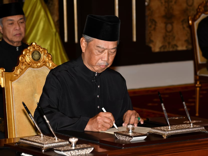 Mr Muhyiddin Yassin signs a document during swearing-in ceremony as Malaysia's prime minister in Kuala Lumpur, Malaysia, March 1, 2020.