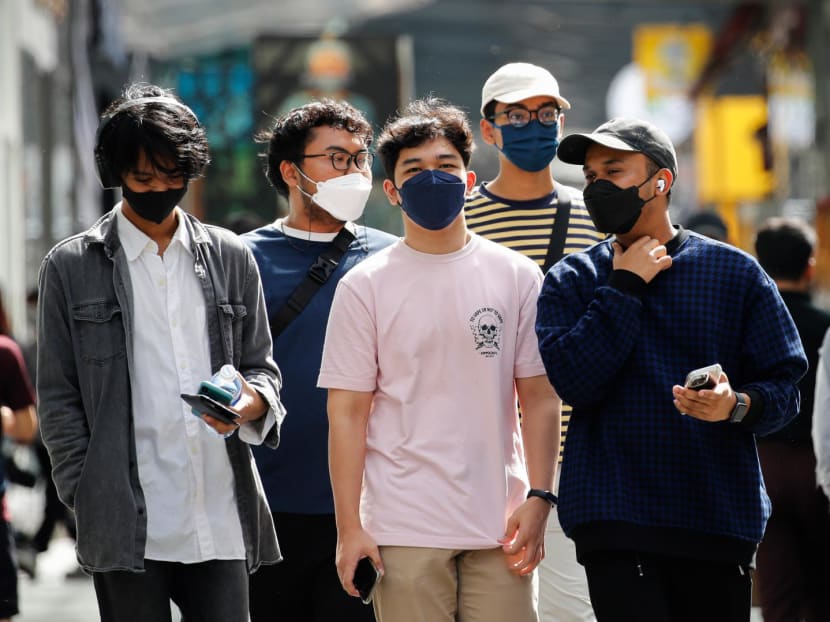 Pedestrians wearing face masks as a preventive measure against the spread of Covid-19 walk along a shopping mall in Kuala Lumpur. 