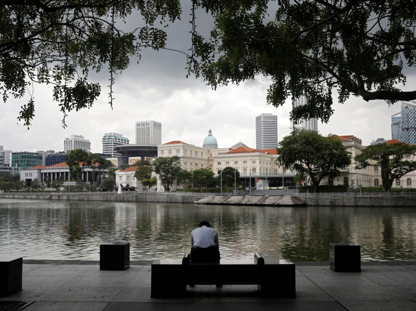 An office worker sits by the river side during lunch hour at the central business district in Singapore on Monday, Dec 14, 2020.