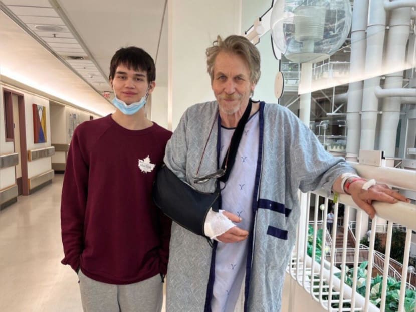 Mr Hugh Harrison (right), 71, and his son Charlie getting their photo taken at the University of Alberta Hospital where he is recovering from an arm injury after a propeller accident.
