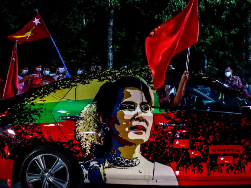 Supporters of the National League for Democracy party wave flags in front of the party's office in Mandalay on Nov 8, 2020, as ballots for the parliamentary elections are being counted after the polls closed.