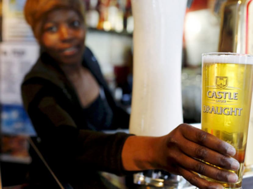 A bartender serving beer produced by SAB Miller, which has accepted a takeover proposal after Anheuser-Busch InBev set out a cash-and-share package. Photo: Reuters