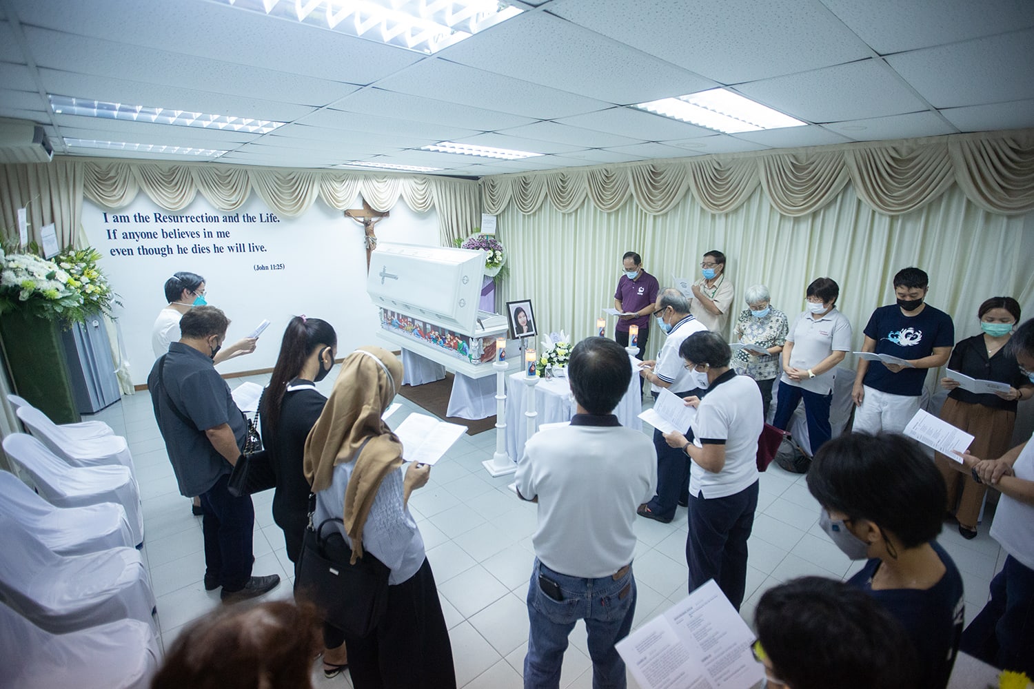 Family and visitors praying at the funeral wake of Home's founder Bridget Tan on April 22, 2022.