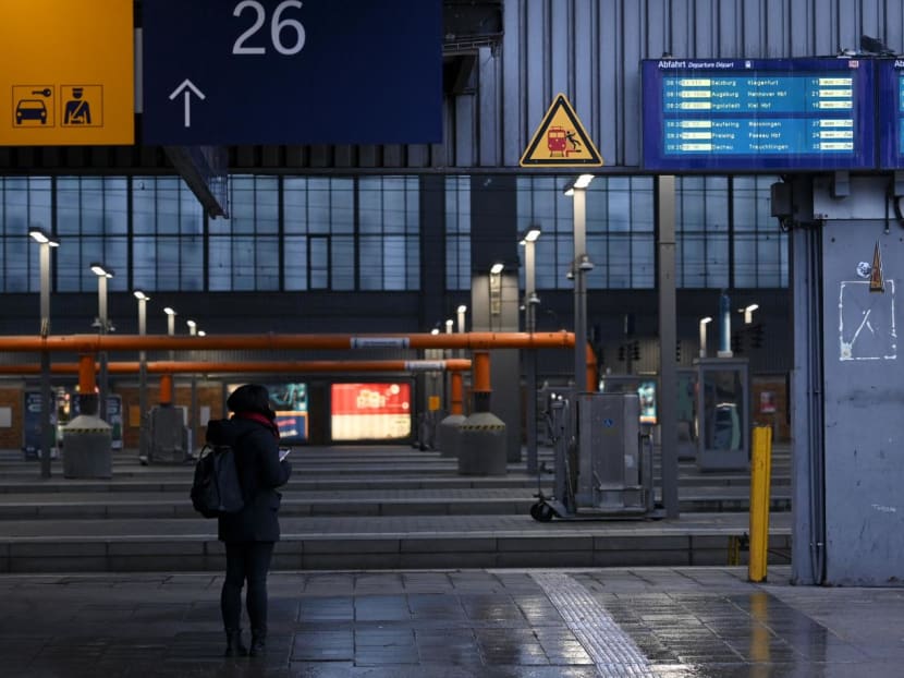 A passenger stands on a platform in an empty Munich central station on March 27, 2023.
