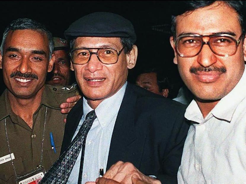 Charles Sobhraj (centre) is escorted by police upon his arrival at Indira Gandhi International Airport near New Delhi on April 7, 1997, from where he will be deported to France.