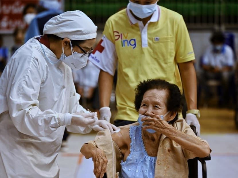 A health worker administering a dose of the AstraZeneca Covid-19 vaccine to an elderly resident at a sports stadium in Phuket on June 29, 2021.