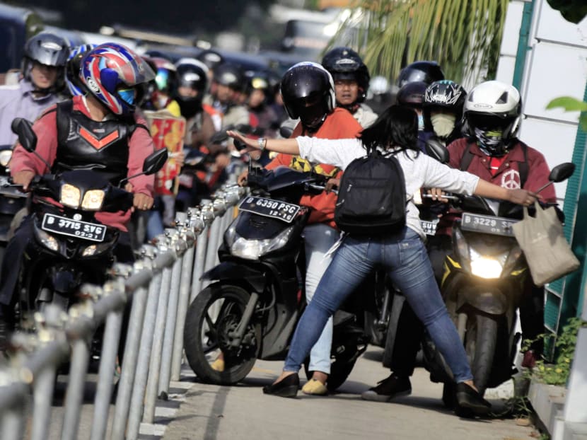 Ms Alfini Lestari (front) stopping motorcyclists from monopolising the sidewalks in Jakarta's busy street. Photo: AFP