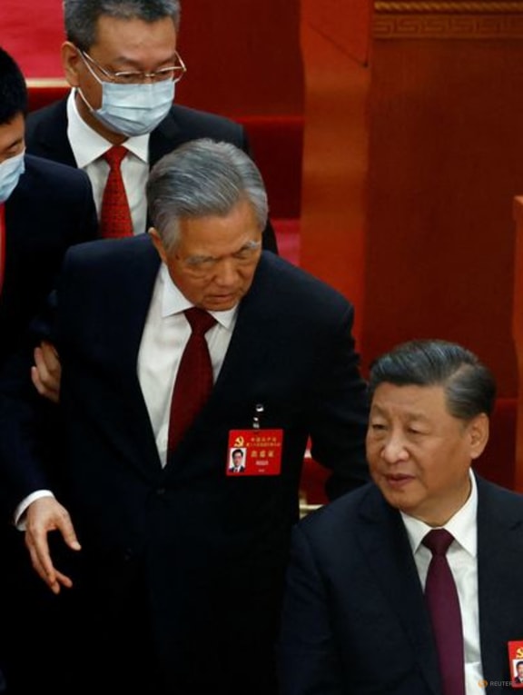 FILE PHOTO: Former Chinese president Hu Jintao leaves his seat next to Chinese President Xi Jinping and Premier Li Keqiang, during the closing ceremony of the 20th National Congress of the Communist Party of China, at the Great Hall of the People in Beijing, China October 22, 2022. REUTERS/Tingshu Wang
