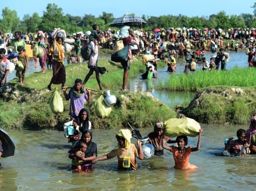 Rohingya refugees walk through a shallow canal after crossing the Naf River as they flee violence in Myanmar to reach Bangladesh.  Malaysia's Deputy Prime Minister Ahmad Zahid Hamidi said his country will build a RM3.5 million (S$1.12 million) field hospital at a Rohingya refugee camp in Bangladesh. Photo: AFP