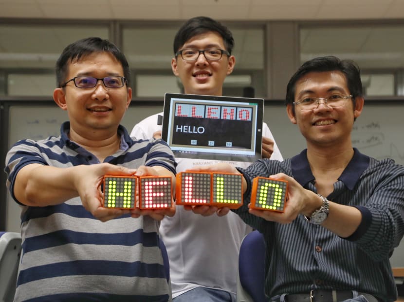 Nanyang Polytechnic lecturers Liaw Sze Wong (left) and Chng Jit Heng (right), together with third-year School of Engineering student Eugene Lee (centre), developed a tool to help pre-school learners with dyslexia. The ProCubeX helps children between the ages of six and eight learn to spell. Photo: Raj Nadarajan/TODAY