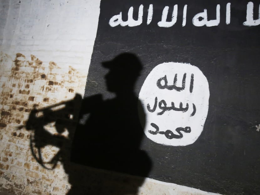 A member of the Iraqi forces walks past a mural bearing the logo of the Islamic State (IS) group in a tunnel that was reportedly used as a training centre by the jihadists. Photo: AFP