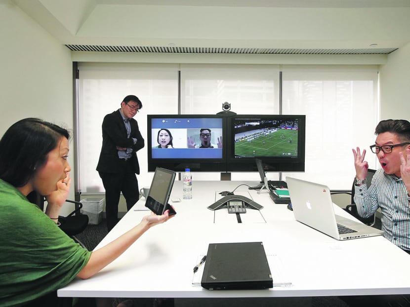 (From left) Polycom staff Cammie Cheng, Eric Wong, and Moses Lim. The firm has adopted a flexi-work hours policy that allows staff to balance their World Cup viewings with work effectively. PHOTO: Wee Teck Hian