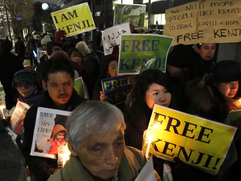 People holding placards take part a vigil in front of Prime Minister Shinzo Abe's official residence in Tokyo, January 30, 2015. Reuters