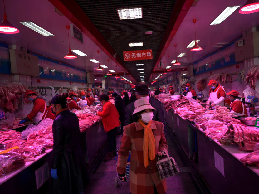 Customers wearing face masks buy pork meat at the Xinfadi wholesale market, as the country is hit by an outbreak of the novel coronavirus disease (COVID-19), in Beijing, China February 19, 2020.