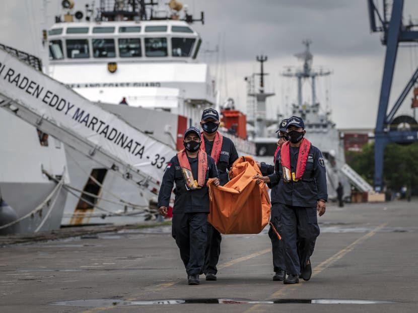 Search and rescue personnel carry a bag containing wreckage from Sriwijaya Air Flight 182 at a port in Jakarta, Indonesia on Jan 13, 2021.