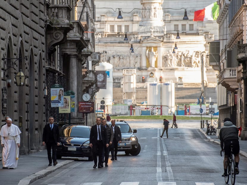 Pope Francis walks on a deserted street in Rome, Italy, to pray at two shrines for the end of the coronavirus pandemic, on March 15, 2020.