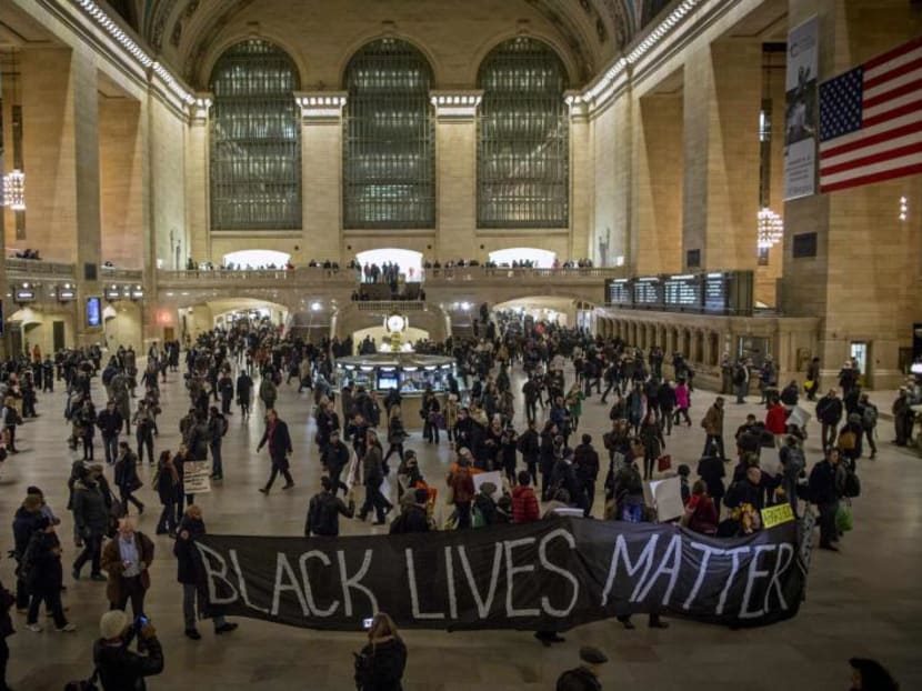 Demonstrators carry a banner through Grand Central Station during a protest against police violence towards minorities in New York, Jan 15, 2015. Both Michael Brown in Ferguson and Eric Garner in New York were shot dead by local police forces. Photo: Reuters