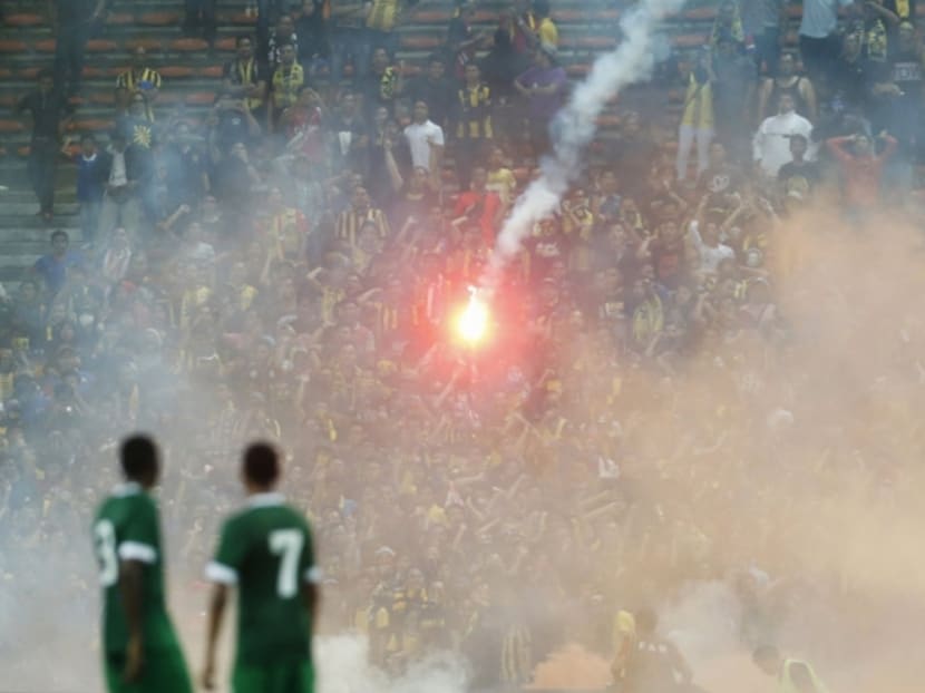 Players from Saudi Arabia watch as a flare is thrown during their 2018 World Cup qualifying match against Malaysia in Kuala Lumpur, September 8, 2015. Photo: Malay Mail Online