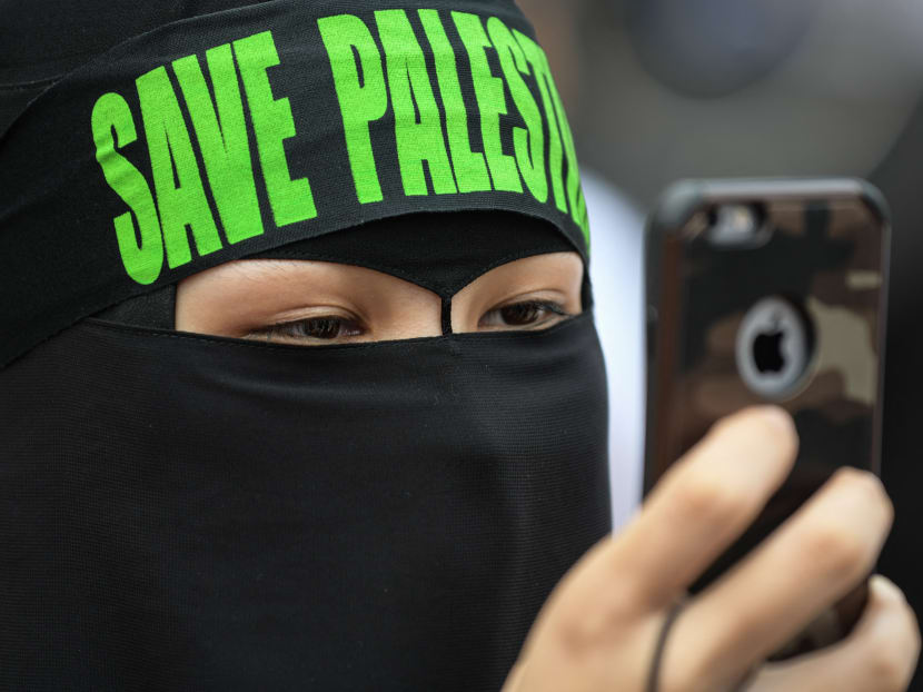 A Malaysian woman wearing a headband reading "Save Palestine" at a rally against US President Donald Trump's recognition of Jerusalem as Israel's capital, in Putrajaya, in 2017. A Malaysian woman wearing a headband reading "Save Palestine" at a rally against US President Donald Trump's recognition of Jerusalem as Israel's capital, in Putrajaya, in 2017.