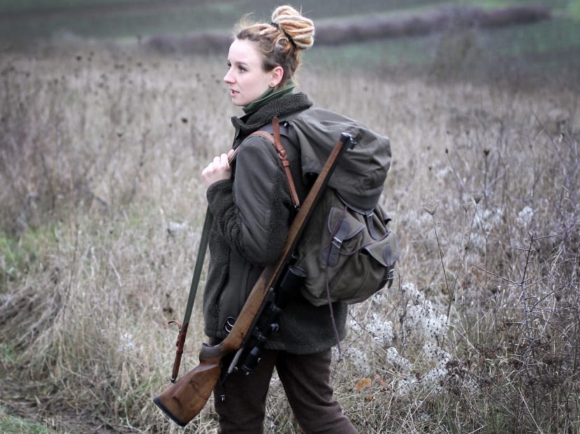 German hunter and winemaker Shanna Reis carries her rifle while hunting in Aspisheim near Bingen, western Germany, on January 7, 2021.
