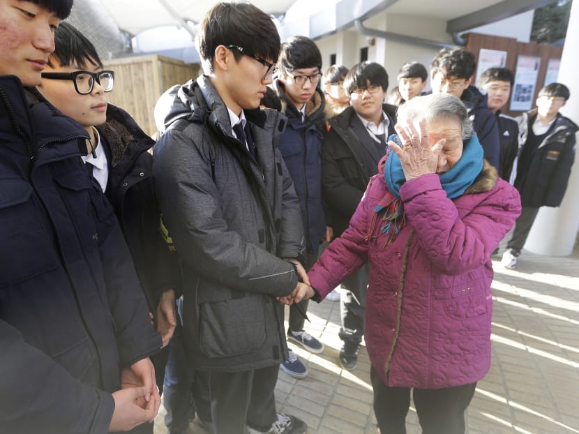 Former South Korean sex slave Park Ok-seon, right, who was forced to serve for the Japanese Army during World War II, wipes her tears as she is comforted by South Korean high school students at the House of Sharing, the home for the living sex slaves, in Gwangju, South Korea, on Dec 29, 2015. Photo: AP