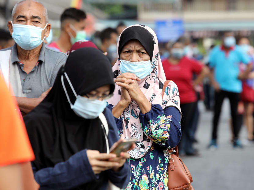People wait in line to be tested for the coronavirus disease at a testing station in Klang, Malaysia, on Dec 2, 2020.