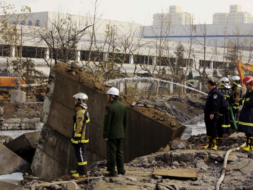 Policemen and firefighters check on a damaged site following a pipeline explosion in Qingdao in east China's Shandong province Friday, Nov. 22, 2013.  AP file photo