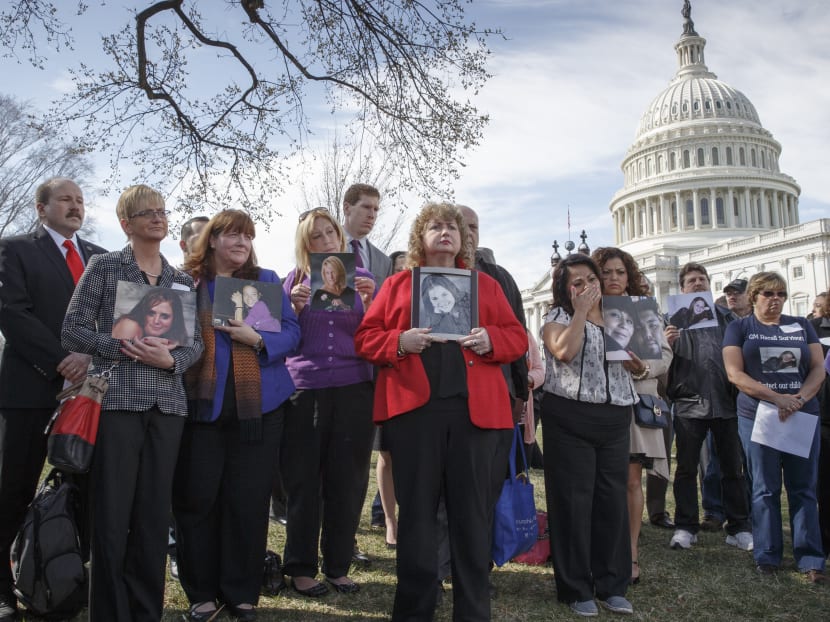 Families of victims of  General Motors safety defects hold photos of their loved ones as they gather on the lawn on Capitol Hill in Washington on April 1, 2014. Photo: AP