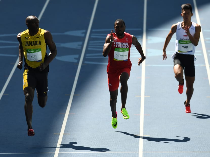 Timothee Yap (R) and Usain Bolt (L) run in the men's 100m heat. Photo: Reuters