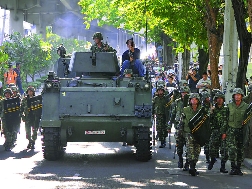 Thai army soldiers march next to an armored personnel carrier. Bloomberg file photo