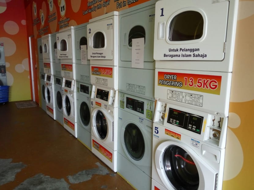 Painted in bright yellow and orange and equipped with around 20 washing machines and dryers, it is a short walk from several Malay kampungs where most of its customers likely come from. Photos: Eileen Ng/TODAY